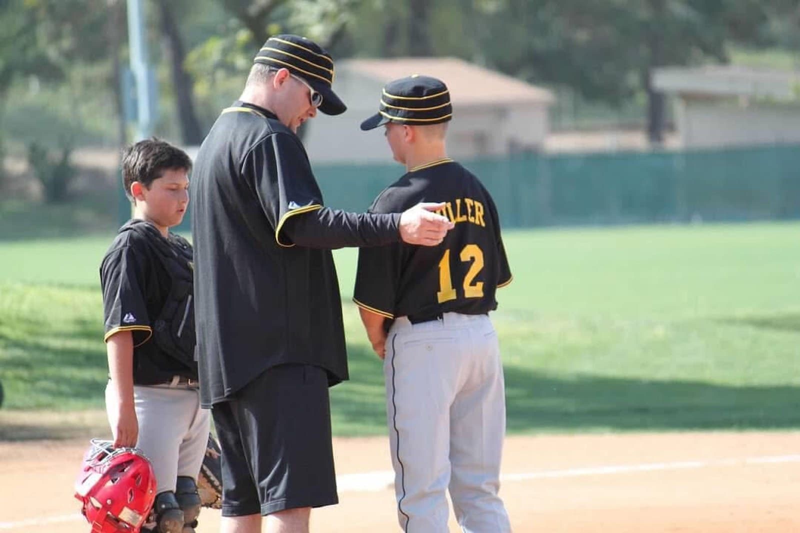 Coach in conversation with athletes on the sideline